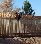 2 men scale border wall with Mexico