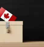 White ballot box and Canadian flag textured vote in front of blackboard. Horizontal composition. Election concept.