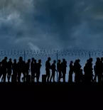 refugees and immigrants standing in front of a border fence