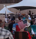 a crowd at the border wall in Arizona for a FAIR rally