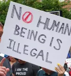 Dick Durban, No Human Being Is Illegal sign