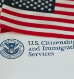 American flag and U.S. Citizenship and Immigration Services logo
