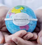 Man holding globe with coronavirus label