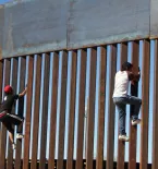 People climbing border wall