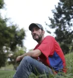 Man sitting on side of grassy knoll
