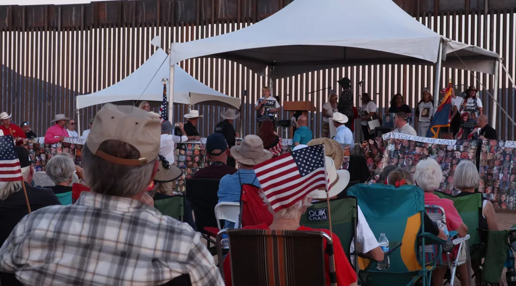 a crowd at the border wall in Arizona for a FAIR rally