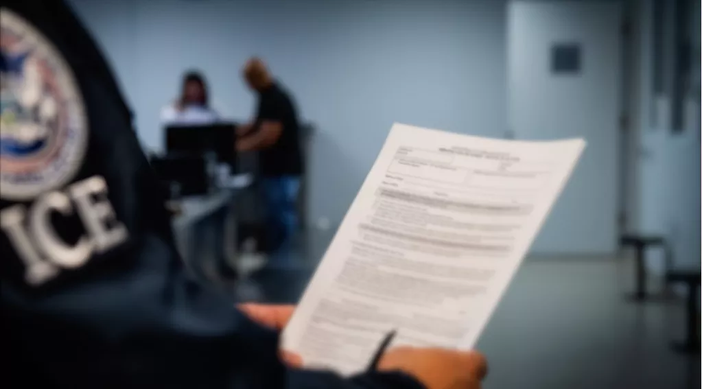 ICE officer holding document