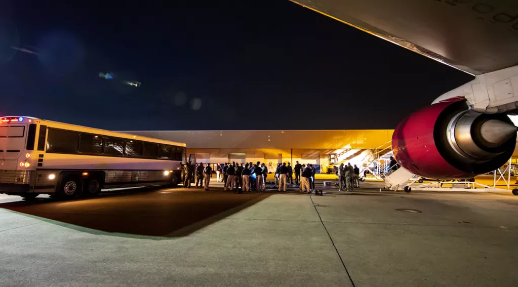 migrants airport bus plane