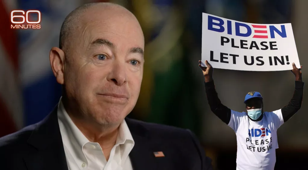 Mayorkas Trying to Keep a Straight Face on 60 Minutes, Migrant wearing shirt and holding sign that reads, "BIDEN PLEASE LET US IN!"