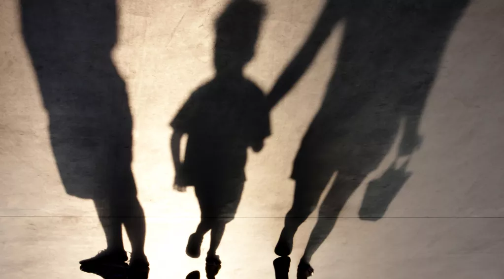 Blurry shadow of two people and a child