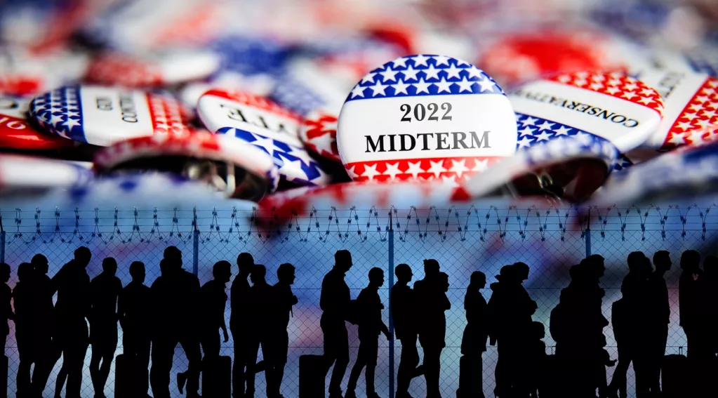 midterms voting buttons, migrants walking by fence